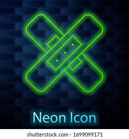 Glowing neon line Crossed bandage plaster icon isolated on brick wall background. Medical plaster, adhesive bandage, flexible fabric bandage. Vector Illustration