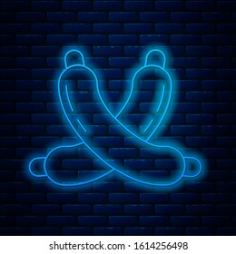 Glowing neon line Crossed sausage icon isolated on brick wall background. Grilled sausage and aroma sign.  Vector Illustration