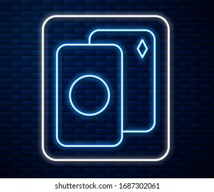 Glowing neon line Deck of playing cards icon isolated on brick wall background. Casino gambling.  Vector Illustration