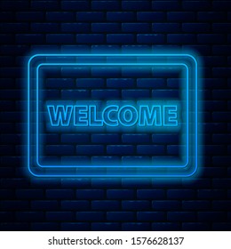 Glowing neon line Doormat with the text Welcome icon isolated on brick wall background. Welcome mat sign.  Vector Illustration