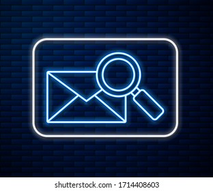Glowing neon line Envelope mail with magnifying glass icon isolated on brick wall background.  Vector Illustration