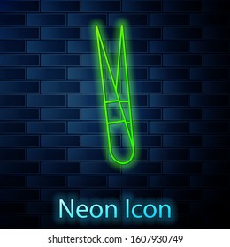 Glowing neon line Eyebrow tweezers icon isolated on brick wall background. Cosmetic tweezers for ingrown hair.  Vector Illustration