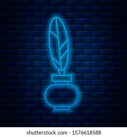 Glowing neon line Feather and inkwell icon isolated on brick wall background.  Vector Illustration