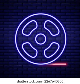 Glowing neon line Film reel icon isolated on brick wall background. Colorful outline concept. Vector