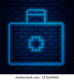 Glowing neon line First aid kit icon isolated on brick wall background. Medical box with cross. Medical equipment for emergency. Healthcare concept.  Vector Illustration