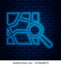 Glowing neon line Folded map with location marker icon isolated on brick wall background.  Vector Illustration