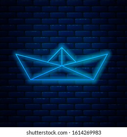 Glowing neon line Folded paper boat icon isolated on brick wall background. Origami paper ship.  Vector Illustration