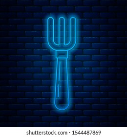 Glowing neon line Fork icon isolated on brick wall background. Cutlery symbol.  Vector Illustration