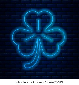 Glowing neon line Four leaf clover icon isolated on brick wall background. Happy Saint Patrick day.  Vector Illustration