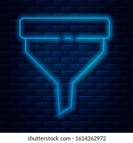 Glowing neon line Funnel or filter icon isolated on brick wall background.  Vector Illustration