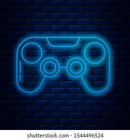 Glowing neon line Gamepad icon isolated on brick wall background. Game controller.  Vector Illustration