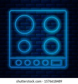 Glowing neon line Gas stove icon isolated on brick wall background. Cooktop sign. Hob with four circle burners.  Vector Illustration