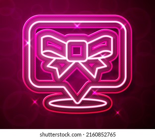 Glowing neon line Gift bow icon isolated on red background.  Vector