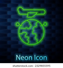 Glowing neon line Globe with flying plane icon isolated on brick wall background. Airplane fly around the planet earth. Aircraft world icon.  Vector