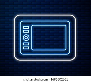 Glowing neon line Graphic tablet icon isolated on brick wall background.  Vector Illustration