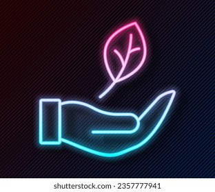 Glowing neon line Hand hold a leaf of the plant icon isolated on black background. Care nature. Leaf shoots with environmental protection.  Vector