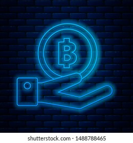 Glowing neon line Hand holding Bitcoin icon isolated on brick wall background. Blockchain technology, digital money market, cryptocoin wallet.  Vector Illustration