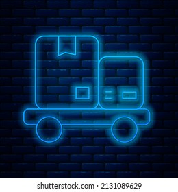 Glowing neon line Hand truck and boxes icon isolated on brick wall background. Dolly symbol.  Vector