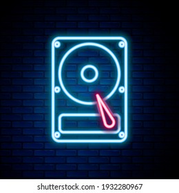 Glowing neon line Hard disk drive HDD icon isolated on brick wall background. Colorful outline concept. Vector