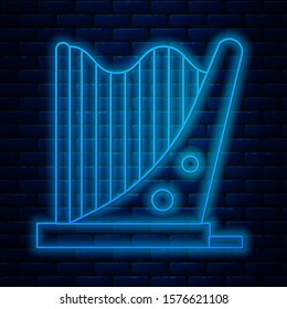 Glowing neon line Harp icon isolated on brick wall background. Classical music instrument, orhestra string acoustic element.  Vector Illustration