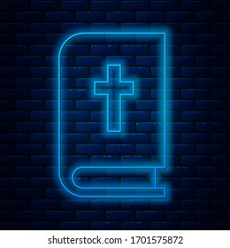 Glowing neon line Holy bible book icon isolated on brick wall background.  Vector Illustration