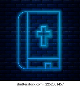Glowing neon line Holy bible book icon isolated on brick wall background.  Vector