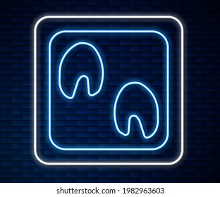 Glowing neon line Horse paw footprint icon isolated on brick wall background.  Vector