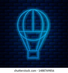 Glowing neon line Hot air balloon icon isolated on brick wall background. Air transport for travel.  Vector Illustration