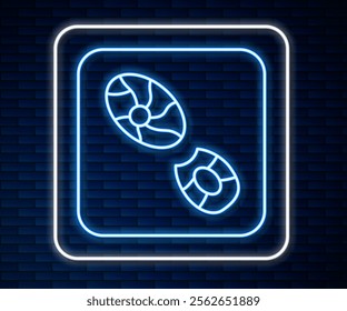 Glowing neon line Human footprints shoes icon isolated on brick wall background. Shoes sole.  Vector