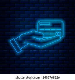 Glowing neon line Human hand holding with credit card icon isolated on brick wall background. Online payment. Pay by card. Financial operations. Vector Illustration Glowing neon line Human hand holding with credit card icon isolated on brick wall background. Online payment. Pay by card. Financial operations. Vector Illustration