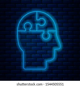 Glowing neon line Human head puzzles strategy icon isolated on brick wall background. Thinking brain sign. Symbol work of brain.  Vector Illustration