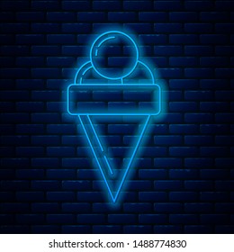 Glowing neon line Ice cream in waffle cone icon isolated on brick wall background. Sweet symbol.  Vector Illustration