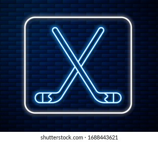 Glowing neon line Ice hockey sticks icon isolated on brick wall background.  Vector Illustration