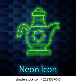 Glowing neon line Islamic teapot icon isolated on brick wall background.  Vector