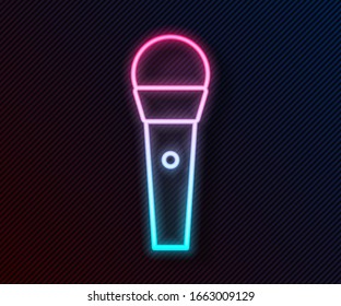 Glowing neon line Karaoke icon isolated on black background. Microphone and monitor.  Vector Illustration