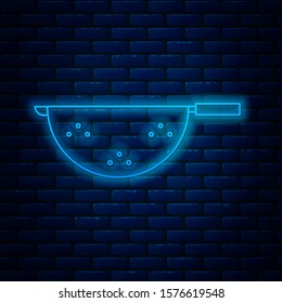 Glowing neon line Kitchen colander icon isolated on brick wall background. Cooking utensil. Cutlery sign.  Vector Illustration