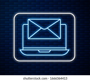 Glowing neon line Laptop with envelope and open email on screen icon isolated on brick wall background. Email marketing, internet advertising concepts.  Vector Illustration