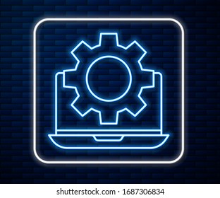 Glowing neon line Laptop and gear icon isolated on brick wall background. Adjusting app, setting options, maintenance, repair, fixing.  Vector Illustration