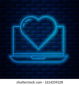 Glowing neon line Laptop with heart icon isolated on brick wall background. Valentines day.  Vector Illustration