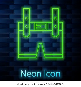 Glowing neon line Lederhosen icon isolated on brick wall background. Traditional bavarian clothing. Oktoberfest outfit. Pants with suspenders. Patrick day.  Vector Illustration