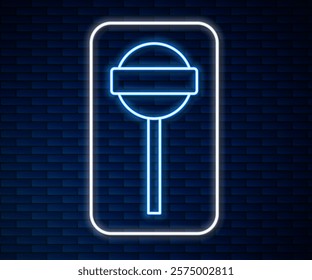 Glowing neon line Lollipop icon isolated on brick wall background. Food, delicious symbol.  Vector