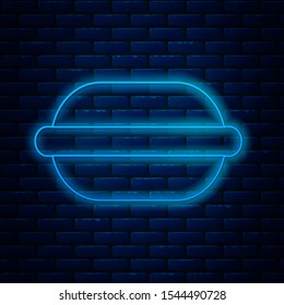 Glowing neon line Macaron cookie icon isolated on brick wall background. Macaroon sweet bakery.  Vector Illustration