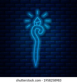 Glowing neon line Magic staff icon isolated on brick wall background. Magic wand, scepter, stick, rod.  Vector Illustration