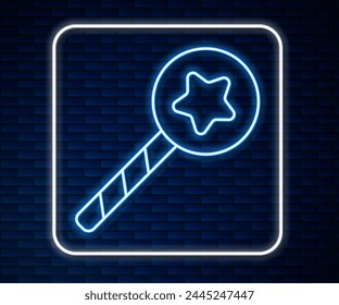 Glowing neon line Magic wand icon isolated on brick wall background. Star shape magic accessory. Magical power.  Vector