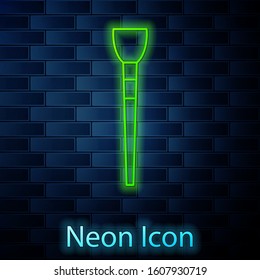 Glowing neon line Makeup brush icon isolated on brick wall background.  Vector Illustration
