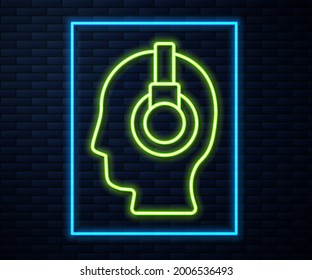 Glowing neon line Man with a headset icon isolated on brick wall background. Support operator in touch. Concept for call center, client support service.  Vector Illustration