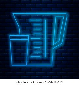 Glowing neon line Measuring cup to measure dry and liquid food icon isolated on brick wall background. Plastic graduated beaker with handle.  Vector Illustration