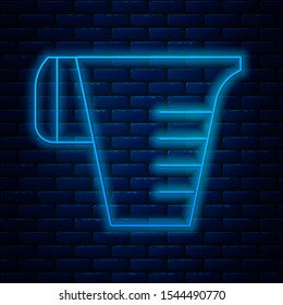Glowing neon line Measuring cup to measure dry and liquid food icon isolated on brick wall background. Plastic graduated beaker with handle.  Vector Illustration