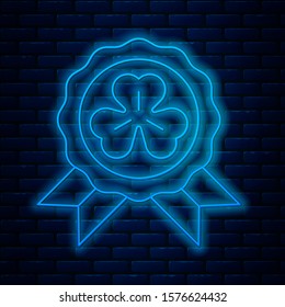 Glowing neon line Medal with four leaf clover icon isolated on brick wall background. Happy Saint Patrick day.  Vector Illustration