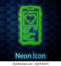 Glowing neon line Mobile phone with heart icon isolated on brick wall background. Valentines day.  Vector Illustration
